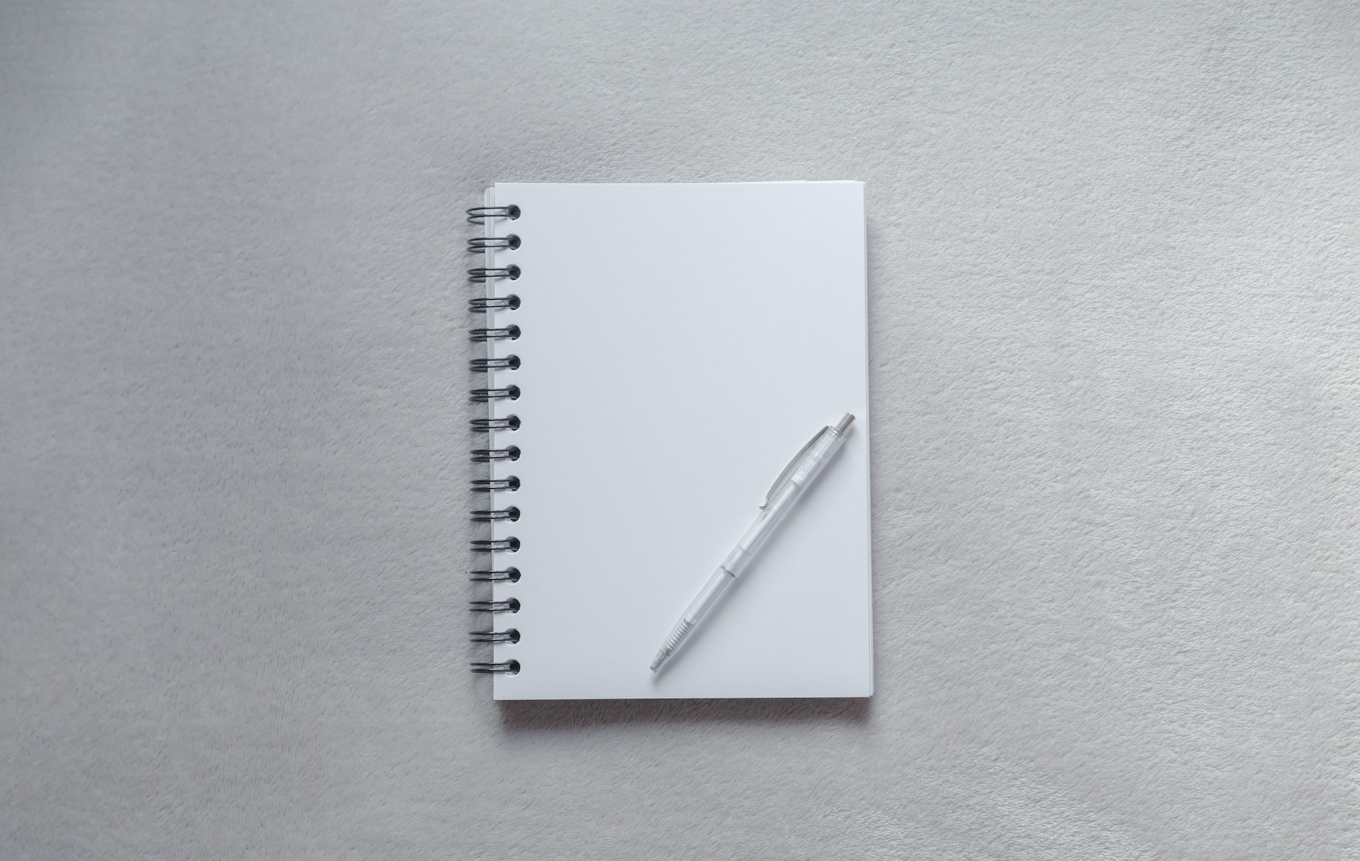 A pen atop a blank notepad